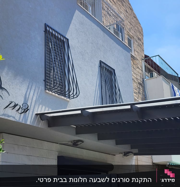 סורגים שחורים על חלונות קיר חיצוני